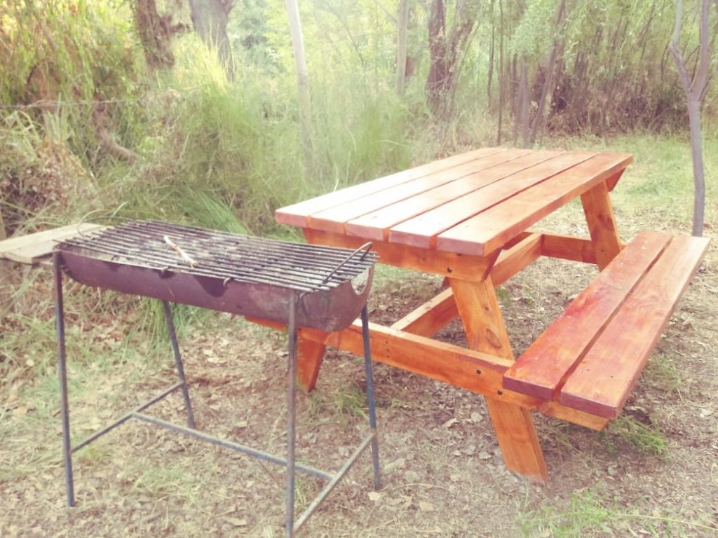 Parrilla y mesa de picnic en un sitio del camping